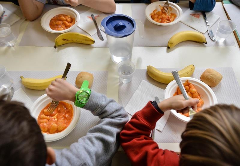 Bambini mangiano in una mensa scolastica.
